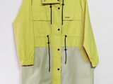 un imperméable jaune et gris suspendu à un cintre