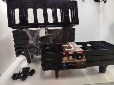 une table sur laquelle sont posés plusieurs récipients en plastique noir