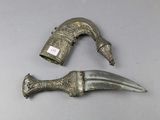 two pieces of silver metal with a knife on top of it