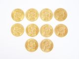 several gold coins arranged in the shape of a heart on a white surface