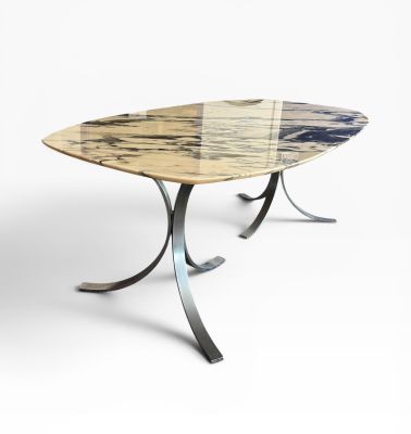 une table à manger ovale en marbre, avec des pieds en métal et un plateau en verre