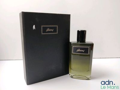 gros plan d'un flacon de parfum à côté d'une boîte