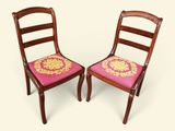 deux chaises en bois avec des coussins roses et jaunes dessus