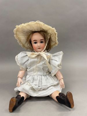 un gros plan d'une poupée portant un chapeau et une robe