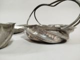two silver spoons sitting next to each other on a table