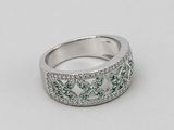 a close up of a white gold ring with green and white diamonds