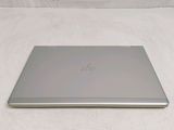 a silver laptop sitting on a white surface