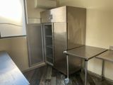 un réfrigérateur en acier inoxydable et une table dans une cuisine
