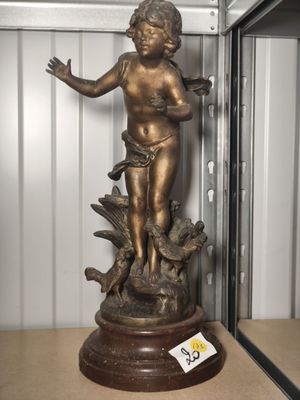 a bronze statue of a child on a pedestal