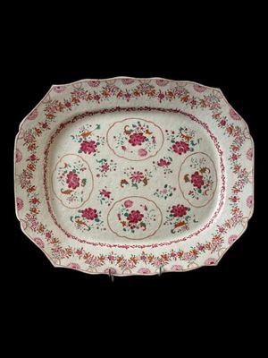 a white plate with pink flowers on it on a black background