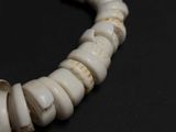 a close up of a necklace made of white beads