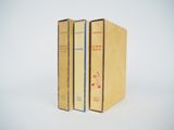 trois livres sont empilés sur une surface blanche