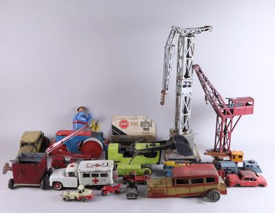 a pile of toy cars and trucks with a crane in the background