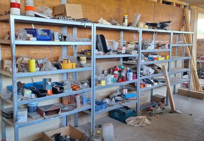 de nombreuses étagères sur lesquelles sont disposés divers objets dans un garage