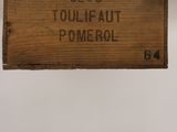 une affiche accrochée au mur sur laquelle on peut lire « Toileaut Pomerol »