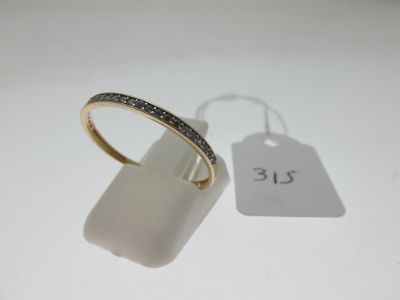 gros plan d'une bague sur une surface blanche avec une étiquette de prix
