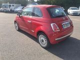 a small red car that is parked in a parking lot