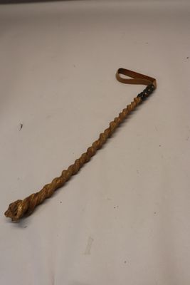 un bâton en bois muni d'un manche, posé sur une surface blanche