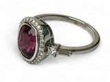 une photo en gros plan d'une bague sertie d'une pierre rouge