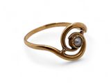 a close up of a gold ring with a pearl in the middle