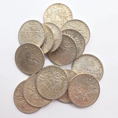 une pile de pièces d'argent sur une surface blanche