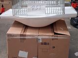 une cage à oiseaux posée sur une pile de cartons