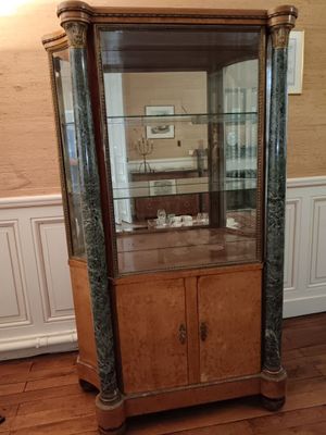 une vitrine en verre dans le coin d'une pièce