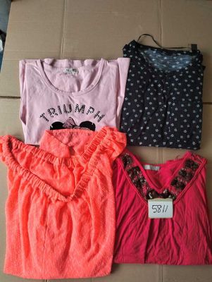 three shirts and a bag are sitting on a cardboard box