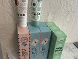 trois boîtes de crème et un tube de crème posés sur une table