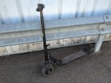 un scooter posé par terre à côté d'un banc