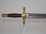 a gold and black sword on display in a glass case