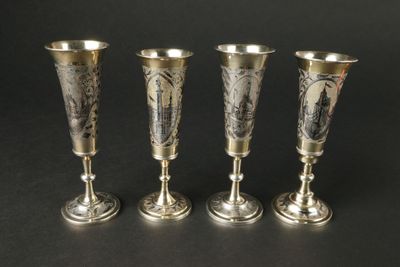 trois vases en argent posés les uns à côté des autres sur une surface noire