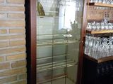 a glass case with wine glasses on it in a store