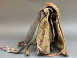 a brown bag with a fur inside of it on the ground