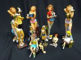 many figurines of different types of women on a black background