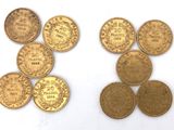 several different types of gold coins on a white surface