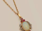an oplite and ruby pendant on a gold chain