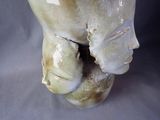 a close up of a vase with a face on it