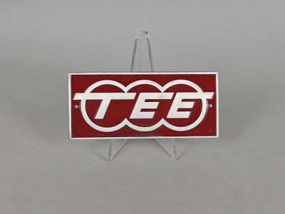 un gros plan d'un logo rouge et blanc posé sur un support métallique