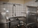 une cuisine équipée d'un évier, d'une cuisinière et d'un robinet