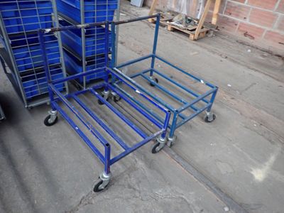 un chariot bleu posé à côté d'une pile de caisses bleues