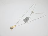 silver and gold triangle necklace with a tag attached to it