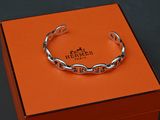une boîte orange sur laquelle est posé un bracelet argenté