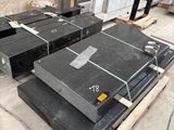 several pieces of black granite are stacked on pallets in a warehouse