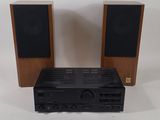 deux haut-parleurs et une chaîne hi-fi posés sur une table
