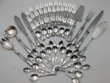 a lot of spoons and forks arranged together on a table
