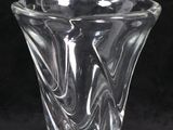 une image représentant un vase en verre transparent sur fond noir