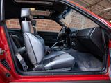 a red car with the door open and the seat up