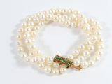 an image of a white pearl bracelet with a gold clasp and emerald clasp