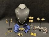 an assortment of jewelry including a necklace, glasses, and a bow tie